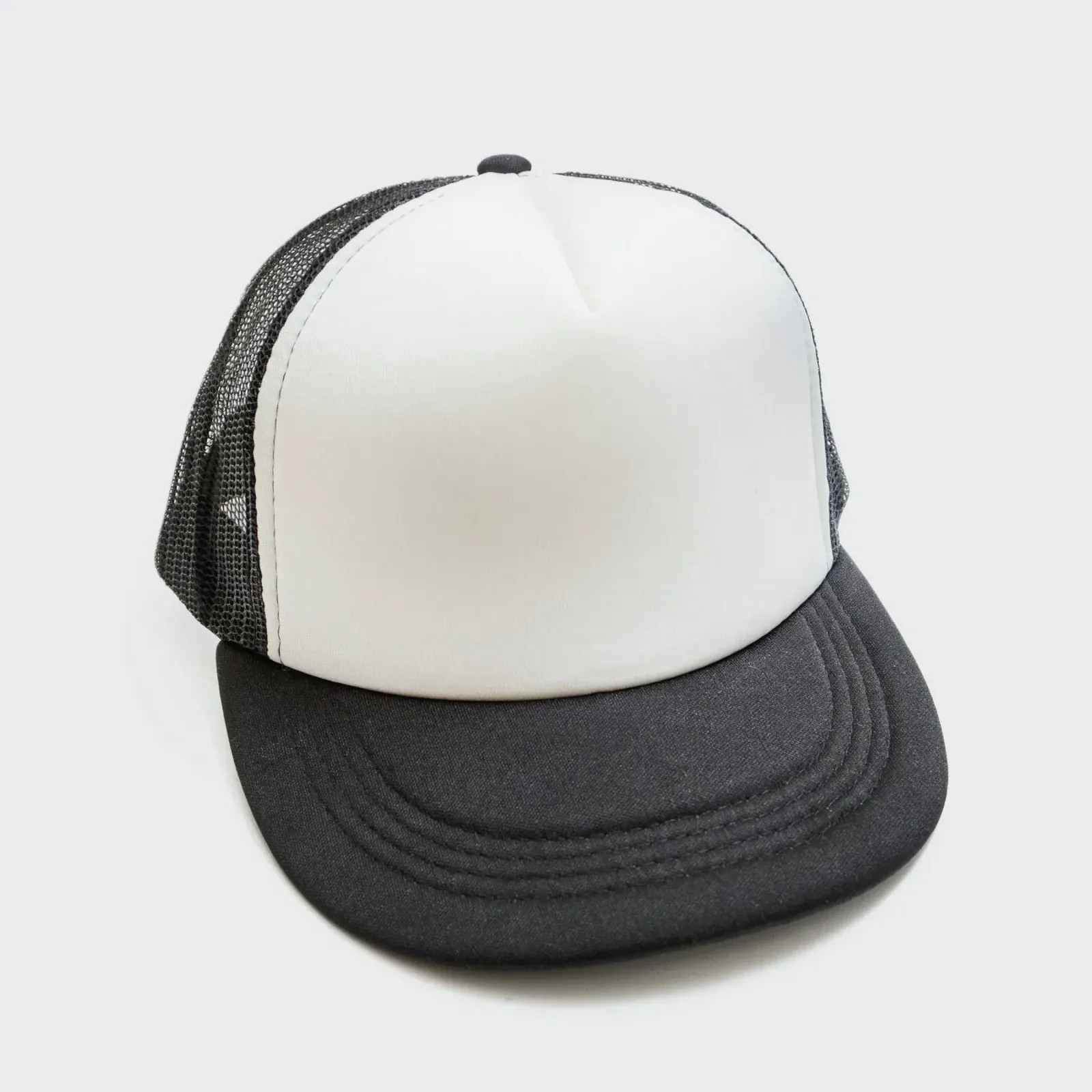 Weiße Trucker-Cap mit Schaumstoff-Front, schwarzem Mesh-Rücken und schwarzem Schirm