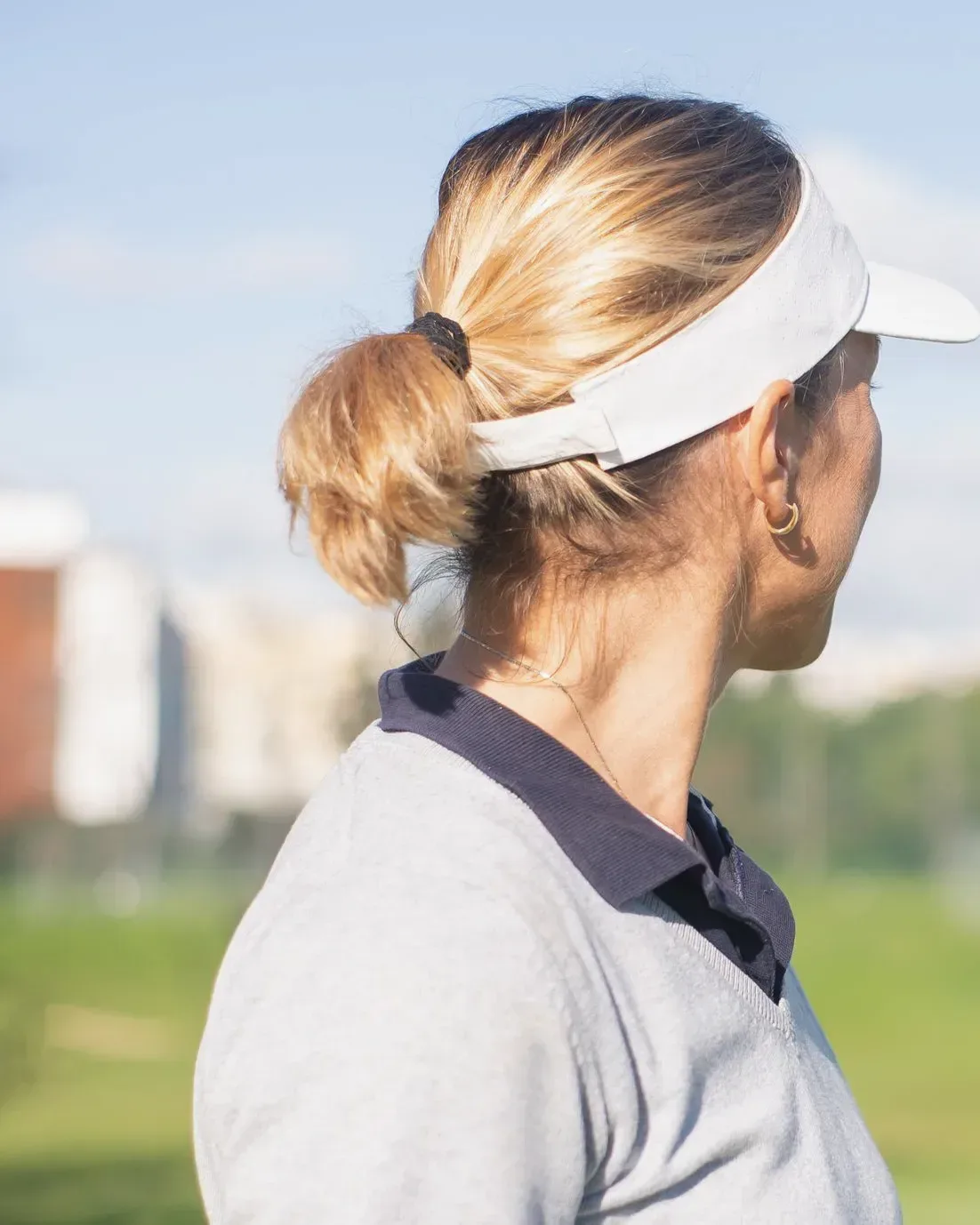 Person beim Golf mit weißem Visor mit gebogenem Schirm